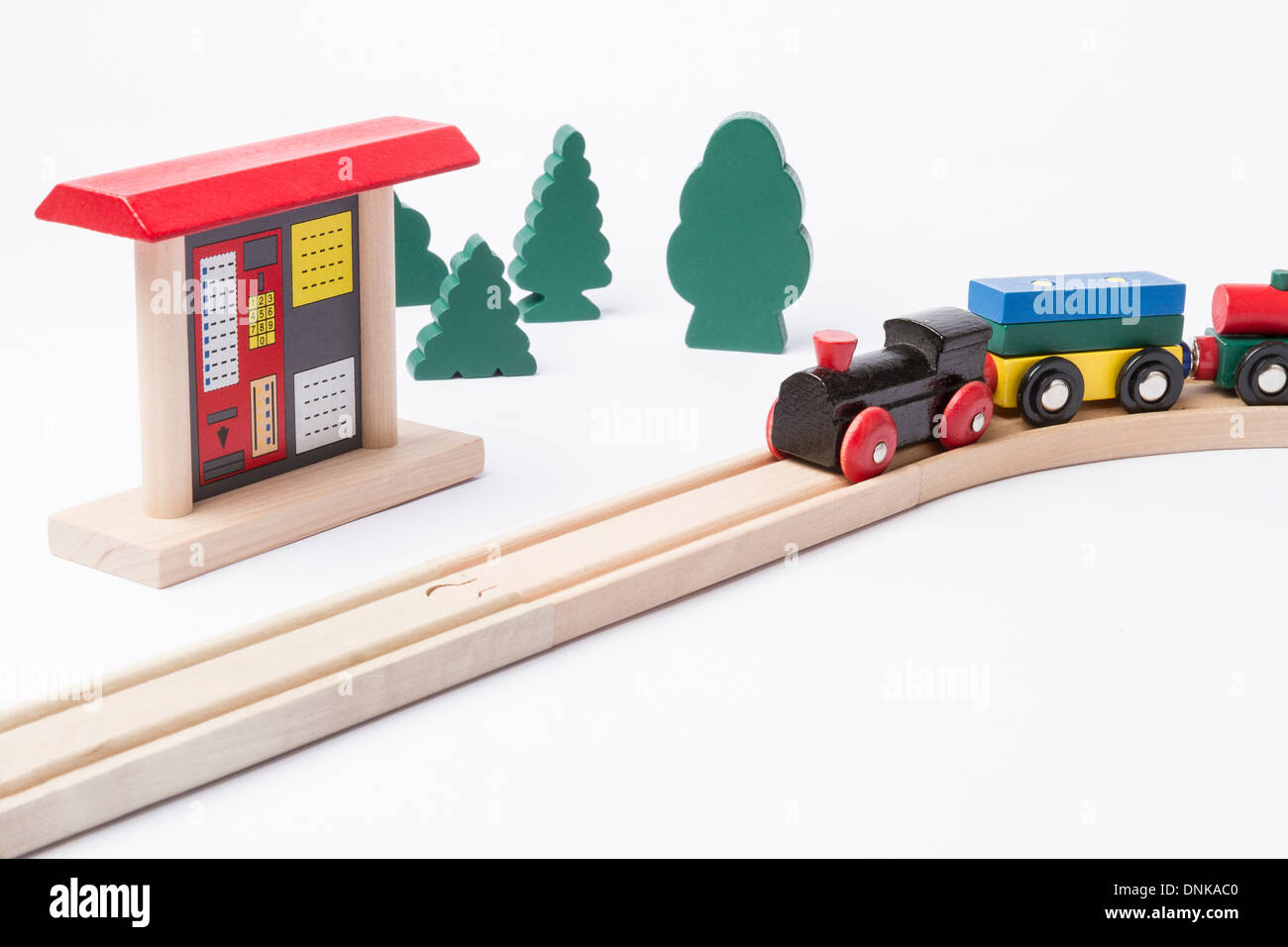 toy ticket machine at wooden railroad track with some trees in background Stock Photo