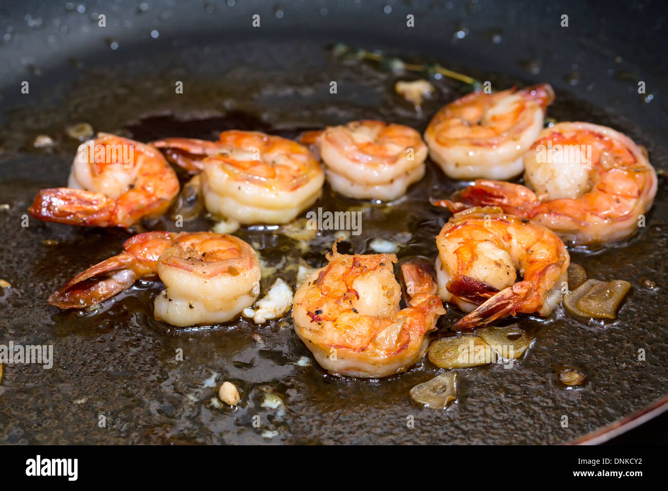 cooking shrimp in a pan in the kitchen at the restaurant Stock Photo
