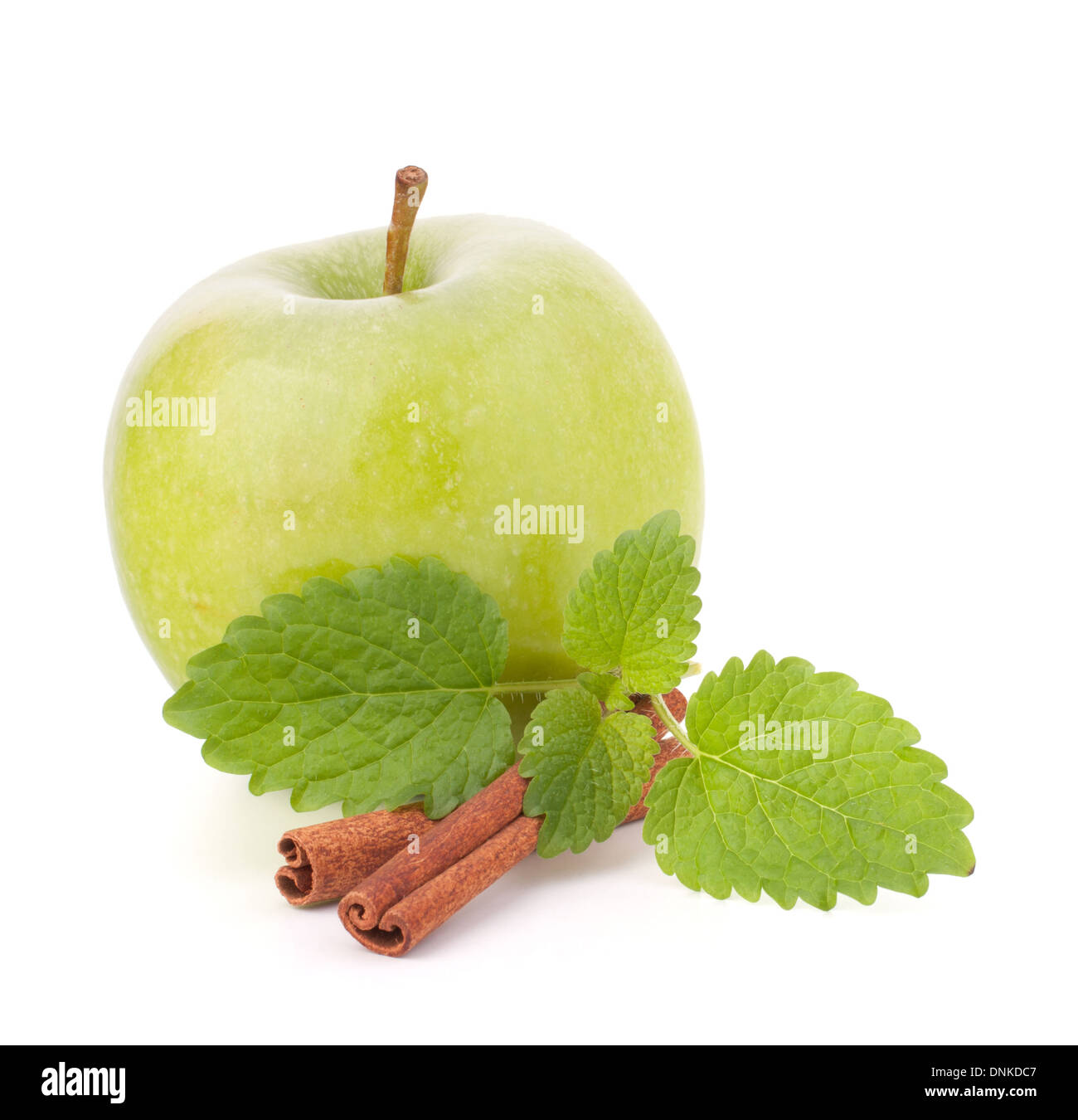 Green apple, cinnamon sticks and mint leaves still life isolated on white cutout. Stock Photo