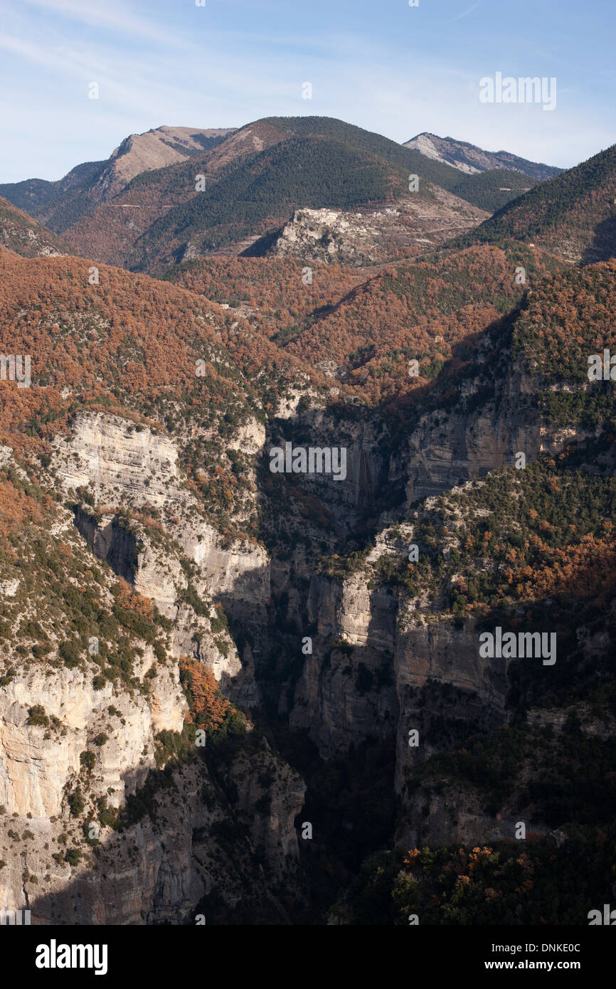 AERIAL VIEW. Lower Cians Gorge with a remote perched medieval village in the distance. Thiéry, Alpes-Maritimes, French Riviera's hinterland, France. Stock Photo