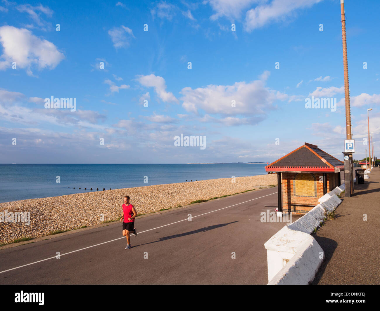 Man jogging by the sea along the quiet seafront promenade in Aldwick, Bognor Regis, West Sussex, England, UK, Britain Stock Photo