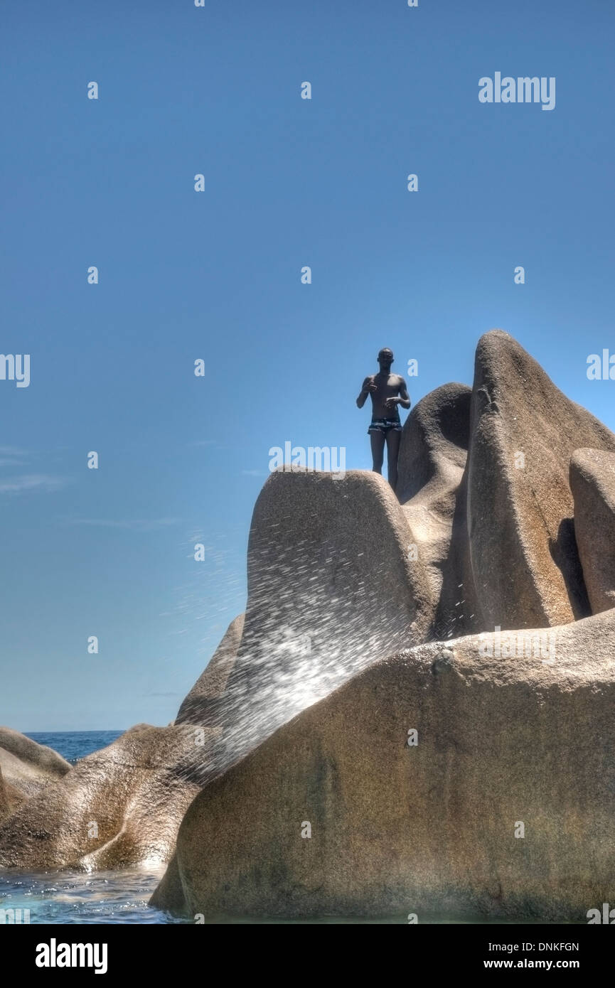 A man on the rock at Seychelles. Anse Marron. Stock Photo