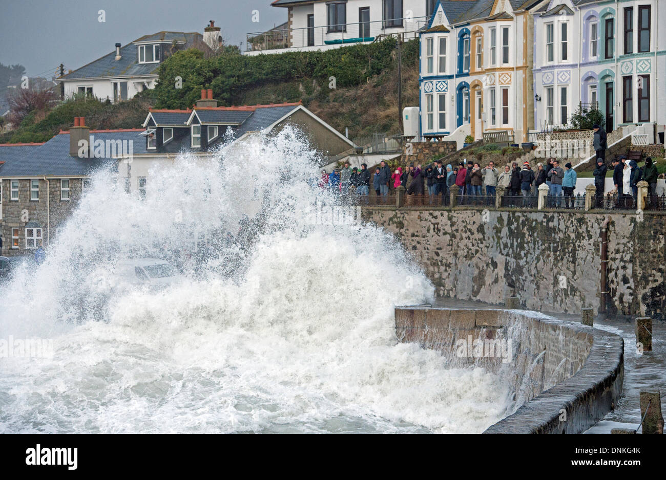 Huge storm waves pound Porthleven Harbour as many storm watchers witness the spectacle Stock Photo