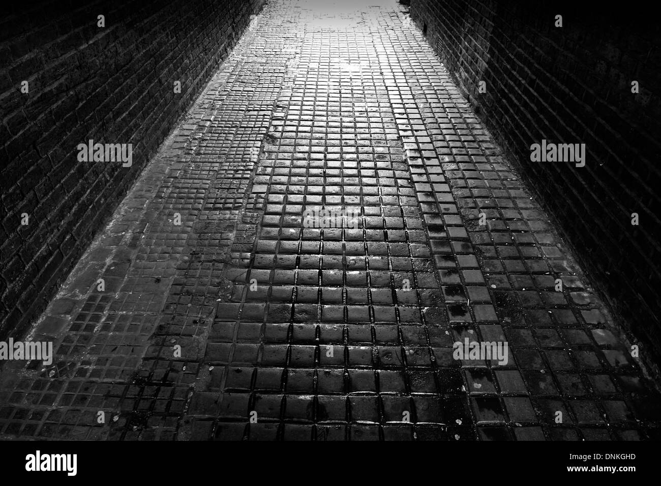 Cobbled alleyway backlit by light in South Woodford, London E18 Stock Photo