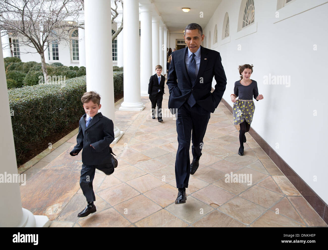 US President Barack Obama races down the Colonnade with Denis McDonough's children en route to the announcement that Denis would become the new Chief of Staff January 25, 2013 in Washington, DC. Stock Photo