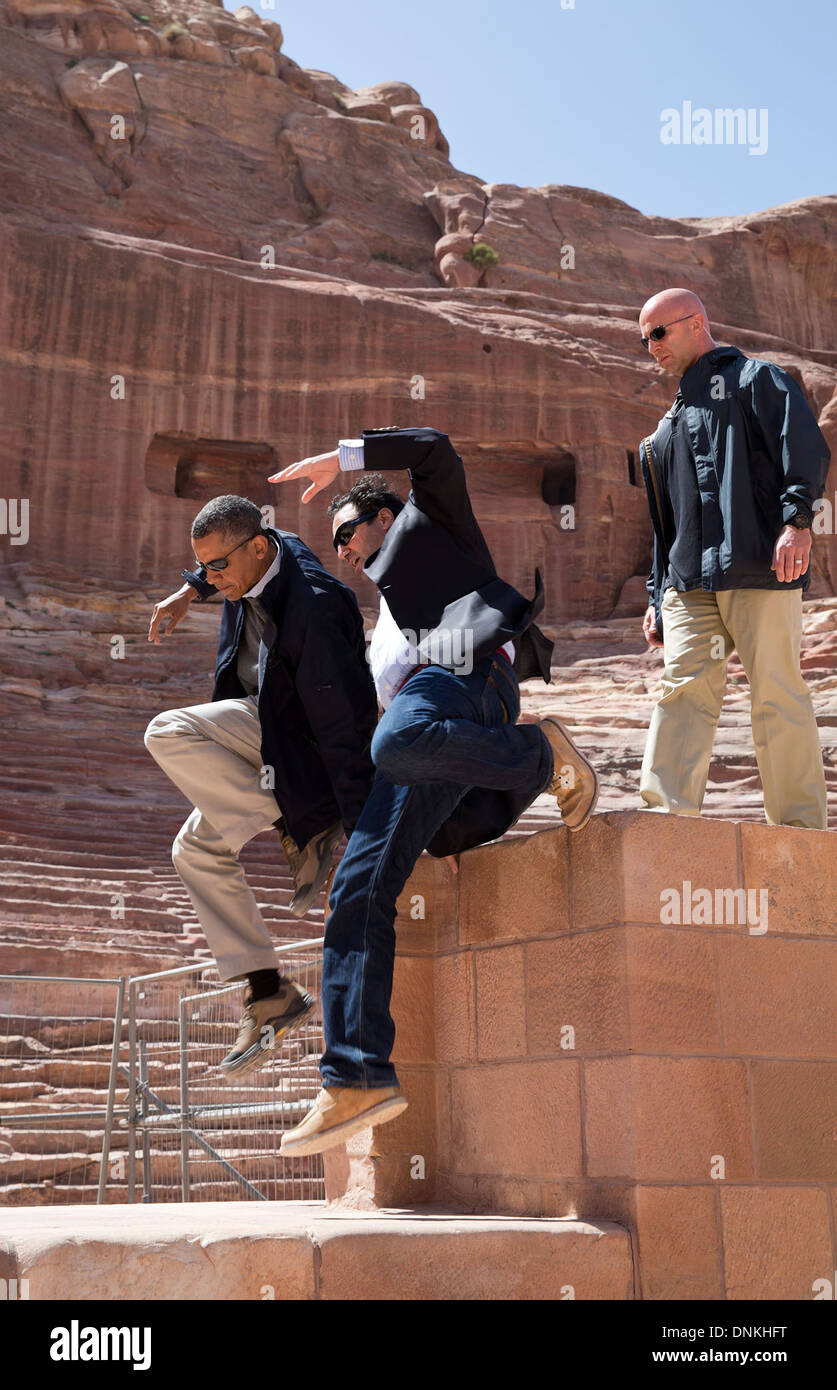 US President Barack Obama and Dr. Suleiman A.D. Al Farajat, a University of Jordan tourism professor, jump from a ledge of the Nabataean Amphitheater March 23, 2013 in Petra, Jordan. Stock Photo