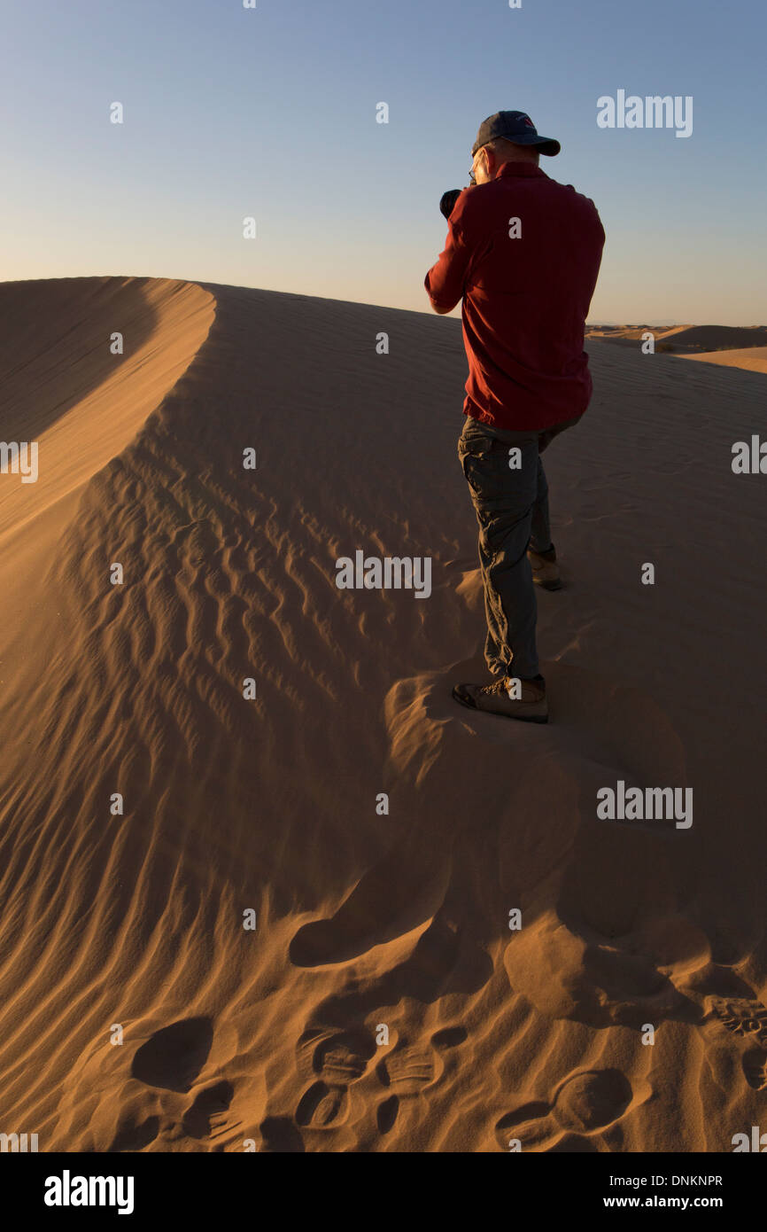 Man Photographing Sand Dunes at Sunset, Algodones Sand Dunes, Imperial Sand Dunes National Monument, Southeastern California Stock Photo