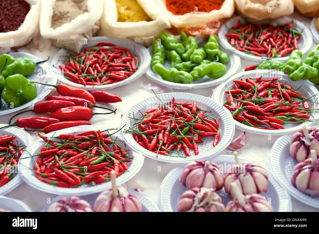 Fresh red and green hot peppers garlic and spices at outdoor Brazilian farmers market Stock Photo