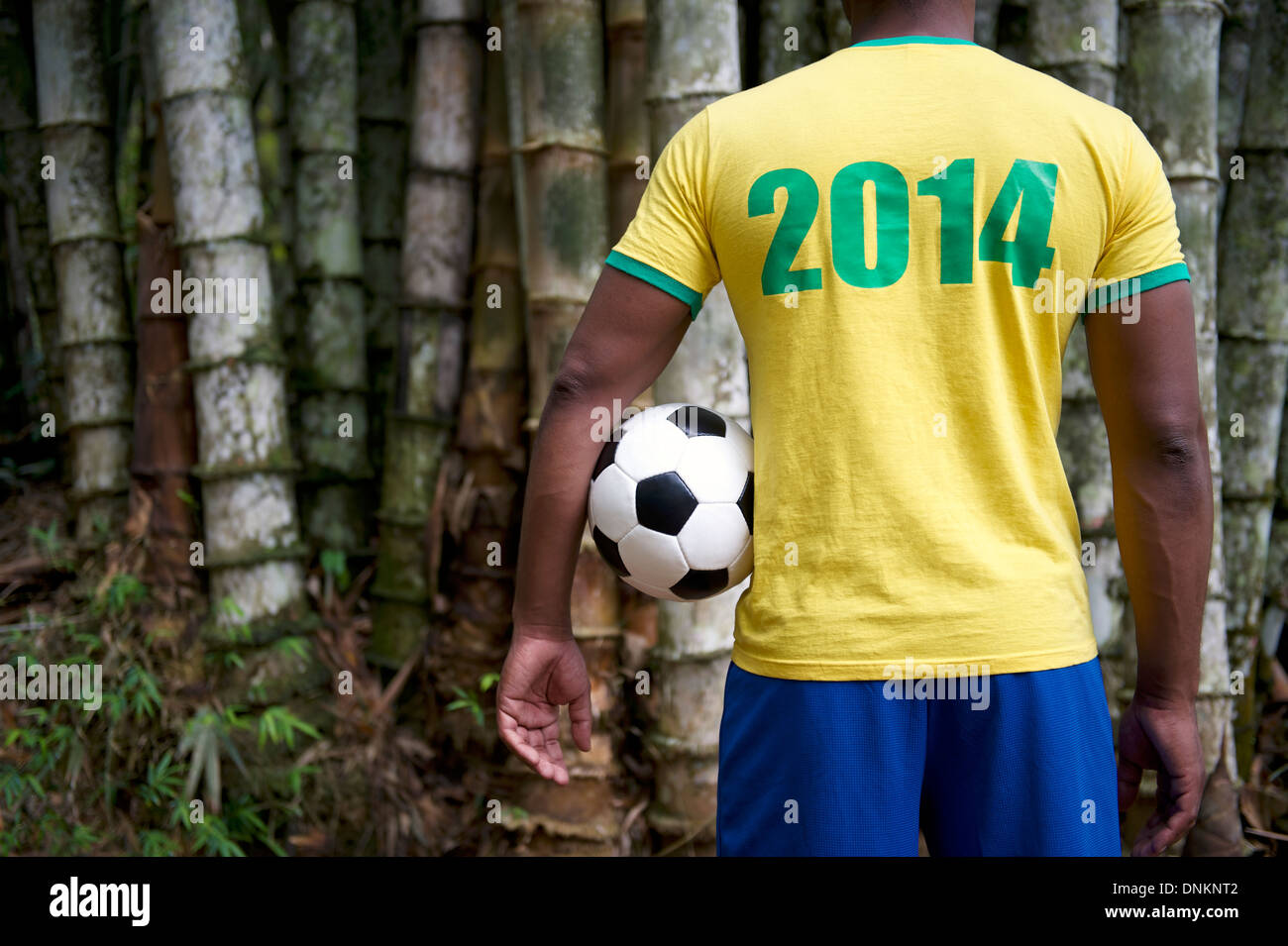 brazilian-soccer-player-in-2014-shirt-standing-in-front-of-tropical