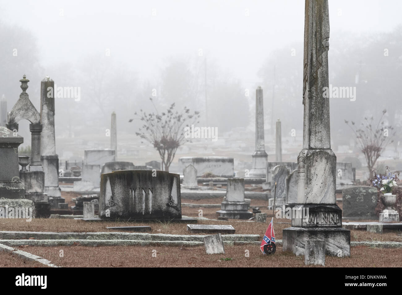 A Confederate veteran medal and flag accompany a grave marker in a fog shrouded cemetery in Lawrenceville, Georgia. (USA) Stock Photo