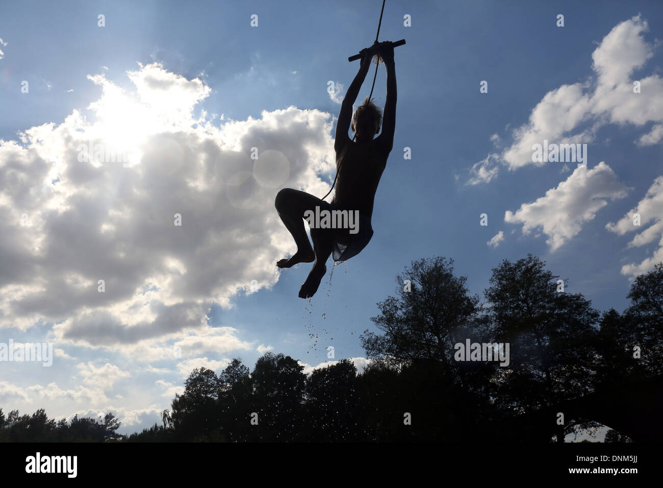 Briescht, Germany, silhouette, boy swinging on a rope through the air Stock Photo