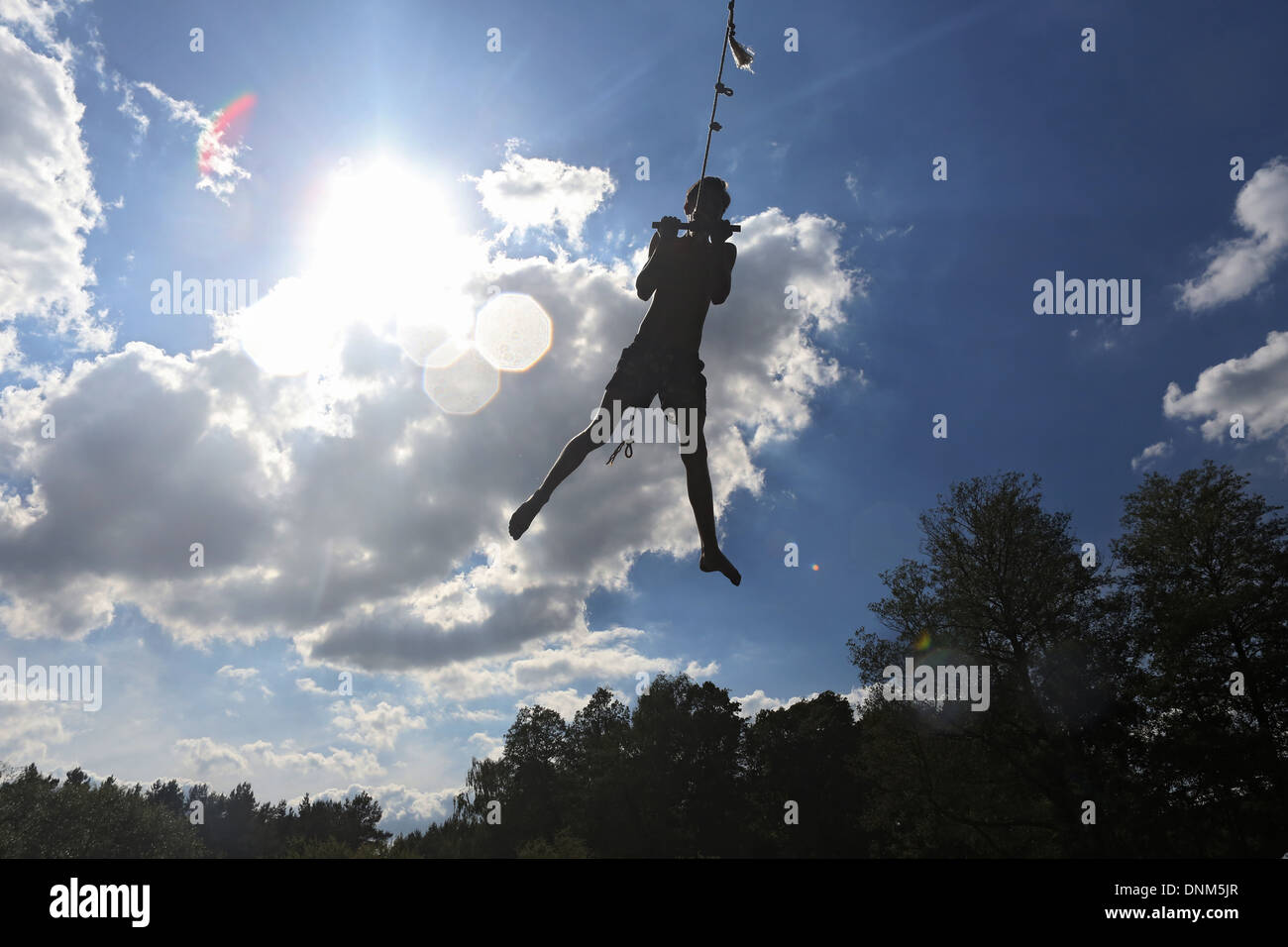 Briescht, Germany, silhouette, boy swinging on a rope through the air Stock Photo