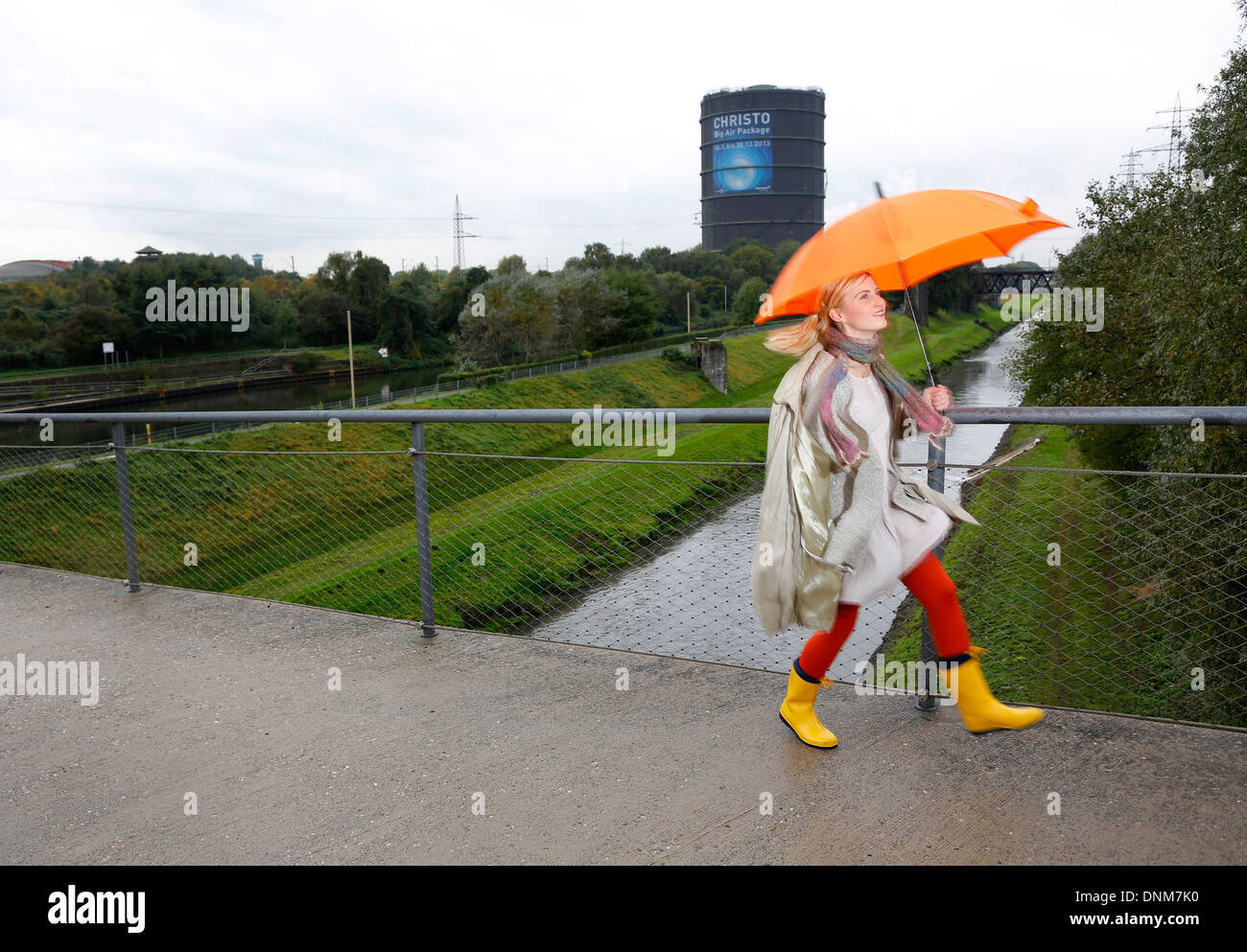 Oberhausen, Germany, a young woman is walking with umbrella in rainy weather Stock Photo