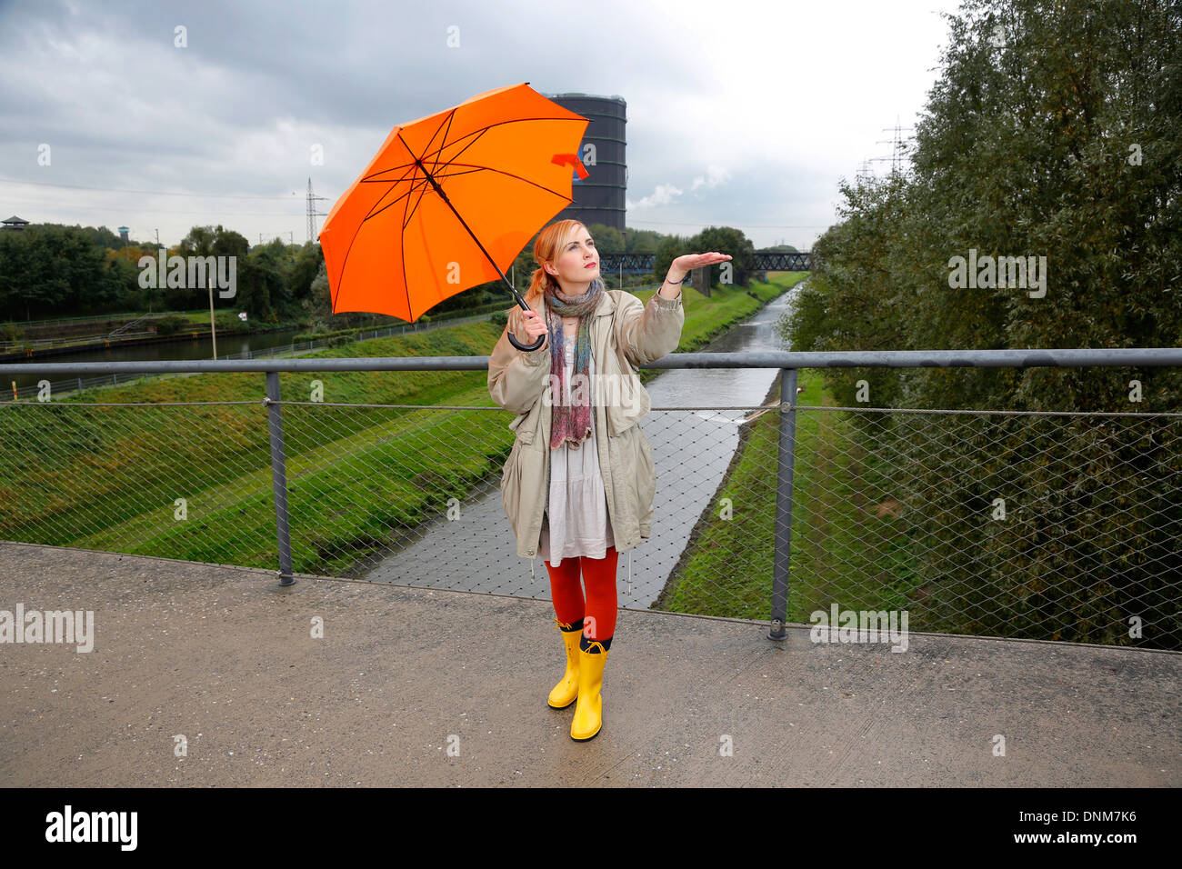 Oberhausen, Germany, a young woman is walking with umbrella in rainy weather Stock Photo
