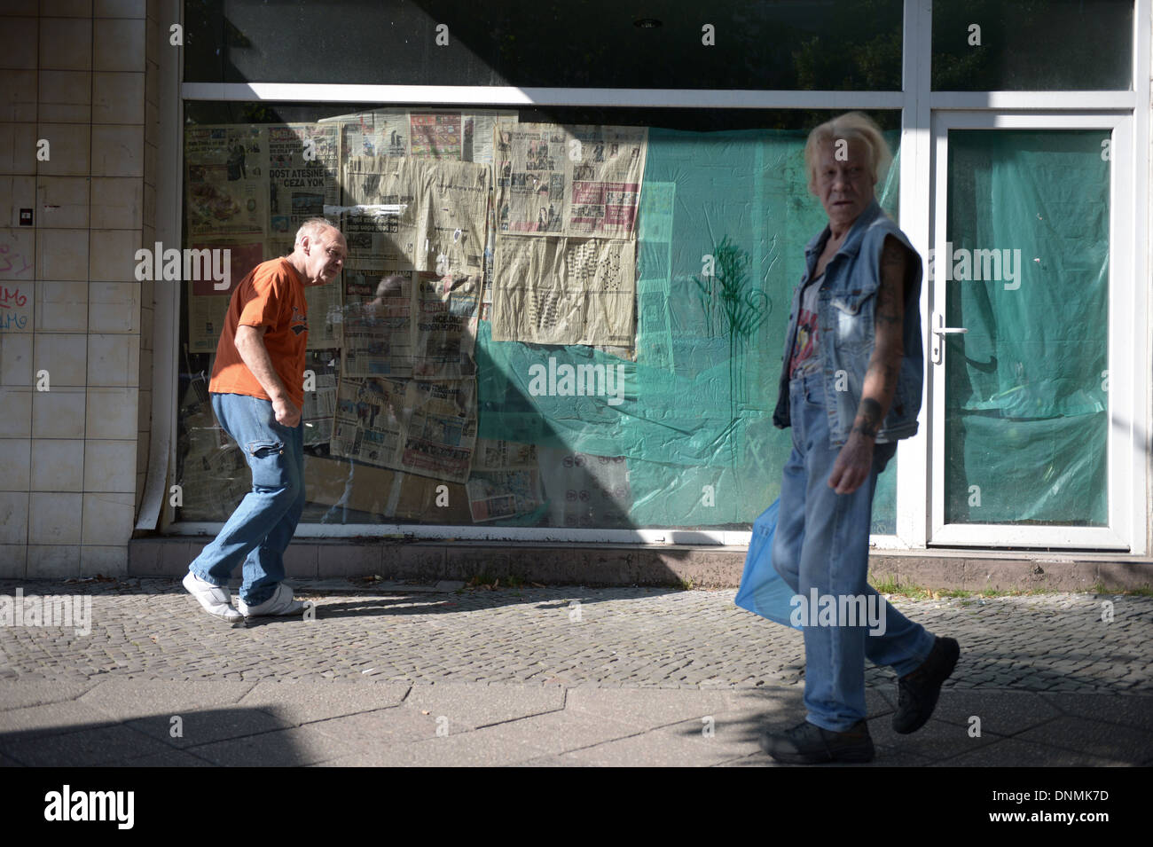 Berlin, Germany, pedestrians walk past a closed shop Stock Photo