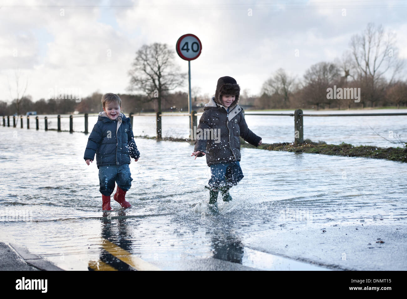 Yalding, Kent, UK. 2nd January 2014. The Environment Agency has issued a flood warning for Yalding Village in County of Kent the first one for 2014 on Thursday 2nd January. Two young children enjoying the water oblivious to the hardship this flooding is causing to local communities along Lee Road the entrance to the Village Credit:  Yon Marsh/Alamy Live News Stock Photo