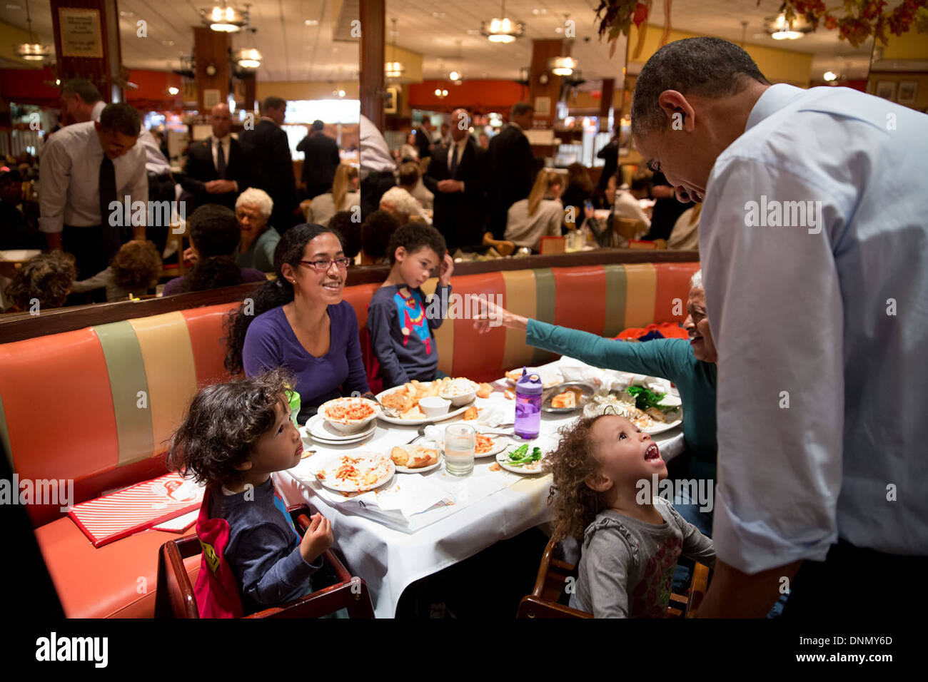 US President Barack Obama talks with young girl as he greets customers at Junior's Cheesecake with New York City mayoral candidate Bill de Blasio October 25, 2013 in Brooklyn, NY. Stock Photo