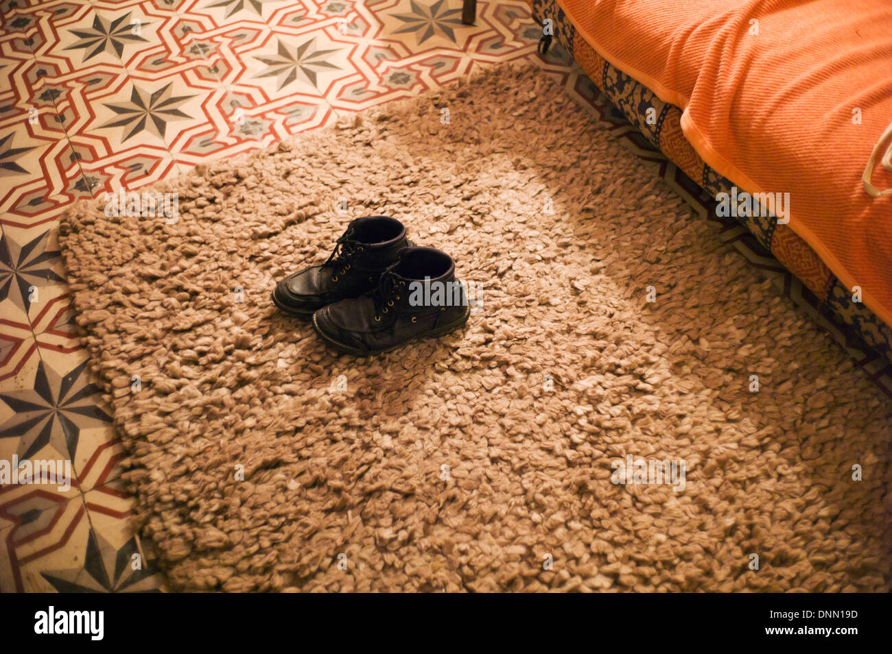 Old boots on rug,tiled floor Stock Photo Alamy