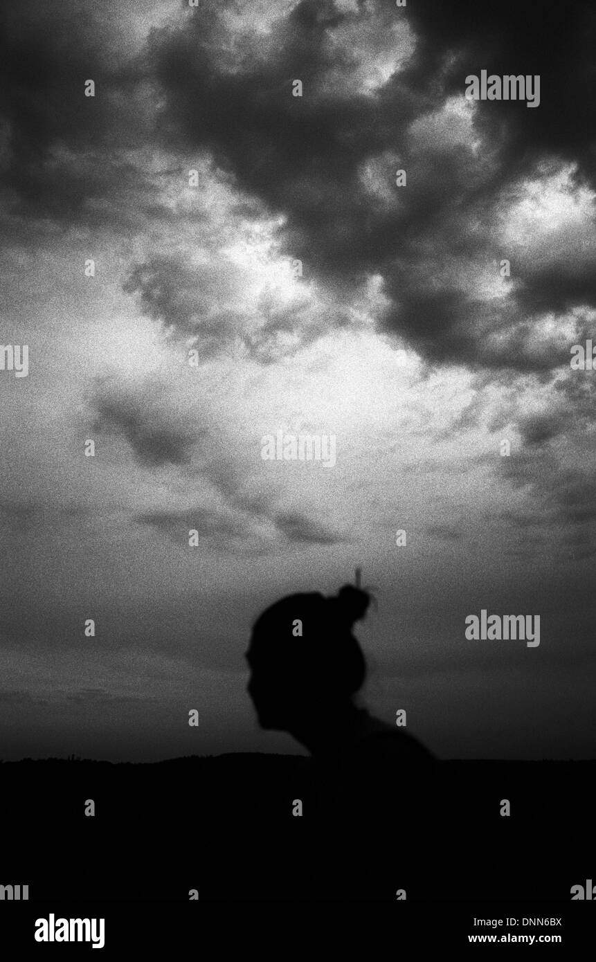 Silhouette of a woman against a stormy sky Weingarten Baden-Württemberg Germany Stock Photo
