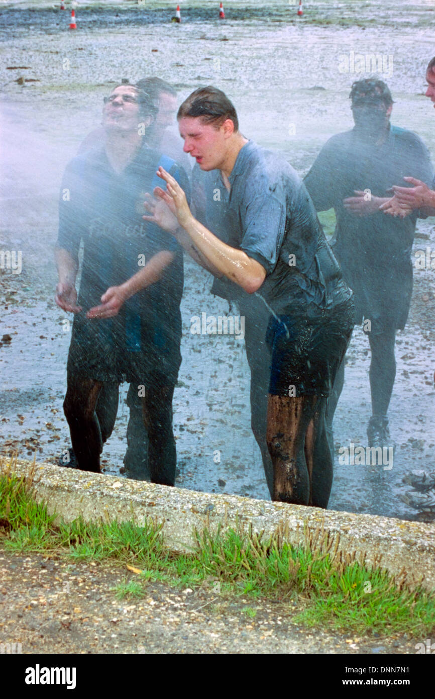 players getting hosed clean after traditional game of mud football on