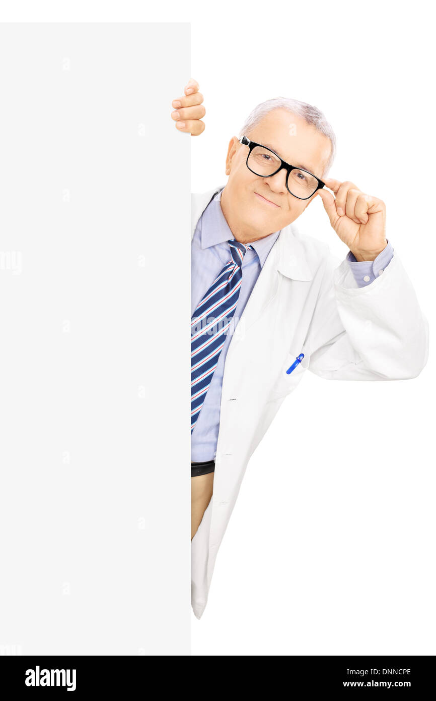 Middle aged doctor with glasses standing next to a blank panel Stock Photo