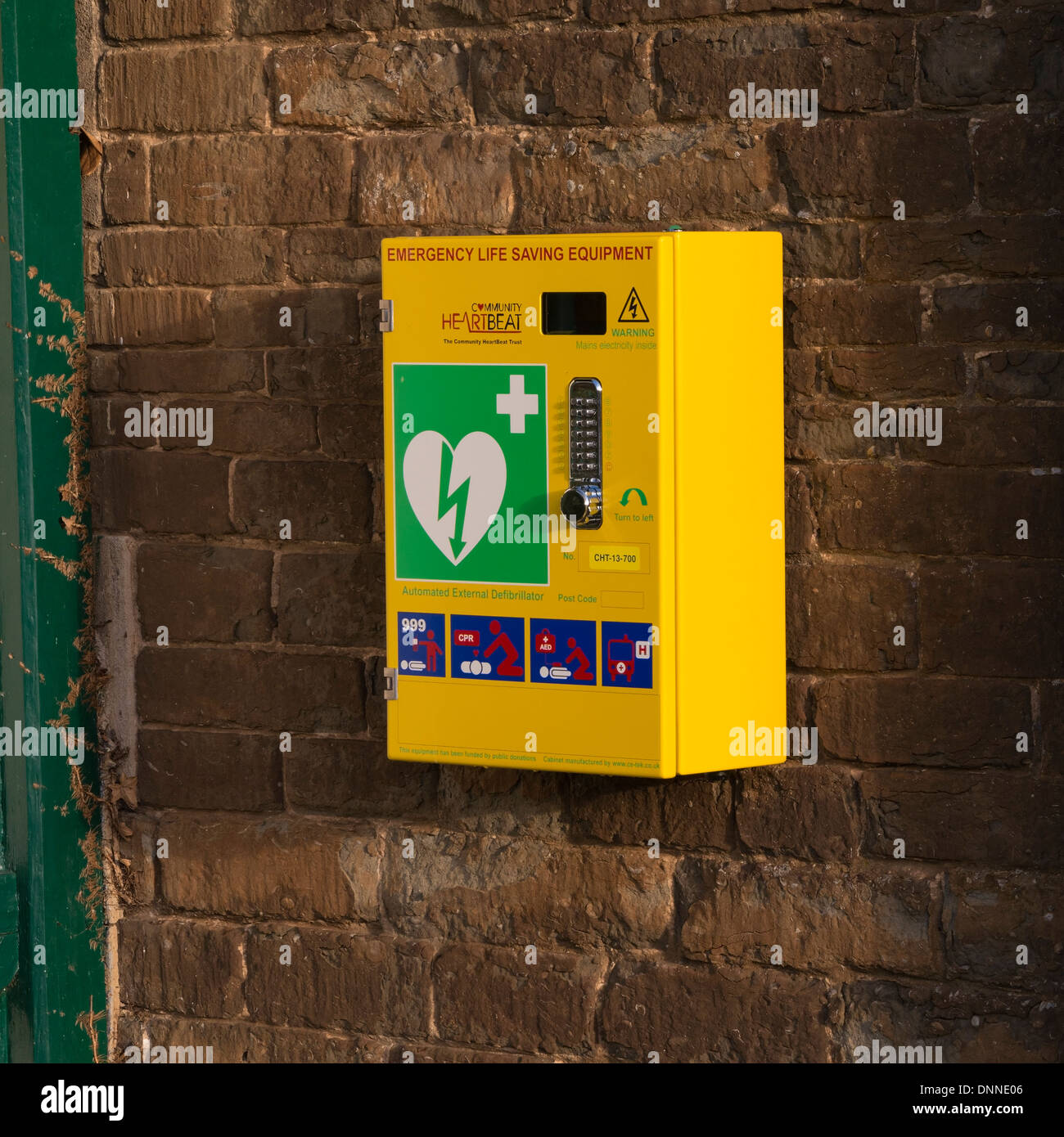 Automated External Defibrillator on Egleton Village Hall wall, Rutland, England, UK Stock Photo