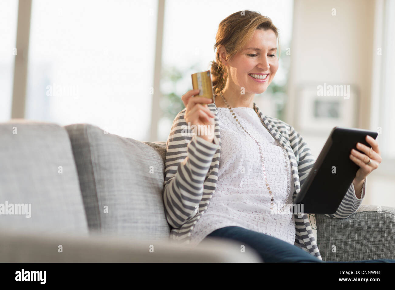 Woman holding tablet pc and credit card Stock Photo