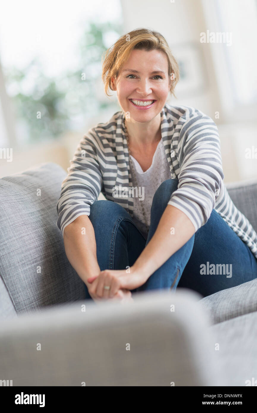 Portrait of woman sitting on sofa Stock Photo - Alamy