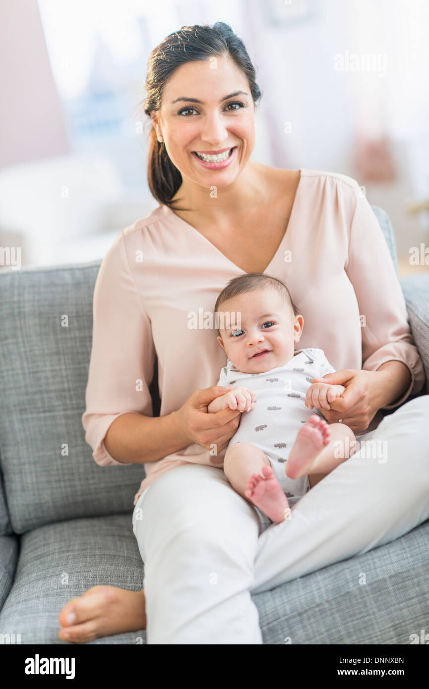 Mother with baby boy (2-5 months) sitting on sofa Stock Photo