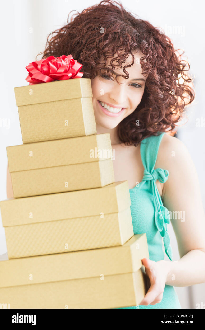 Woman holding stack of gifts Stock Photo