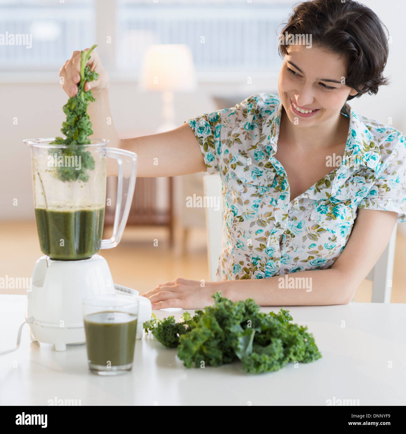 Woman preparing healthy drink with kale Stock Photo