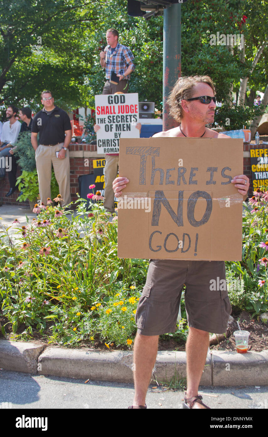 Asheville, North Carolina, USA - July 26, 2013: Christians and Atheist hold conflicting signs on July 26, 2013 in Asheville, NC Stock Photo