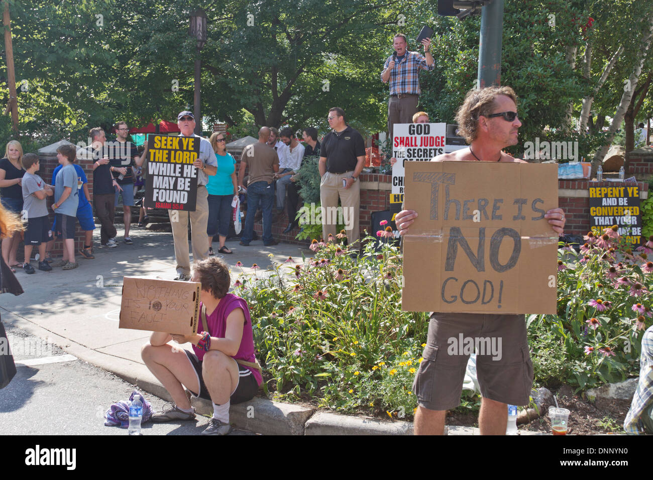 Asheville, North Carolina, USA - July 26, 2013: Christians and Atheists hold conflicting signs at the annual Bele Chere Festival Stock Photo