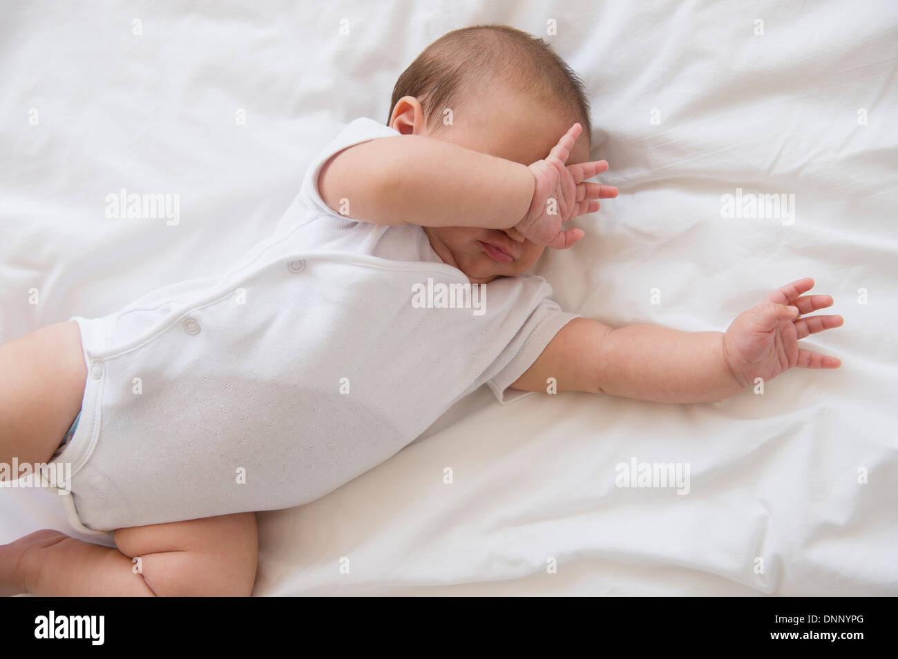 Baby girl (2-5 months) lying on bed and crying Stock Photo - Alamy