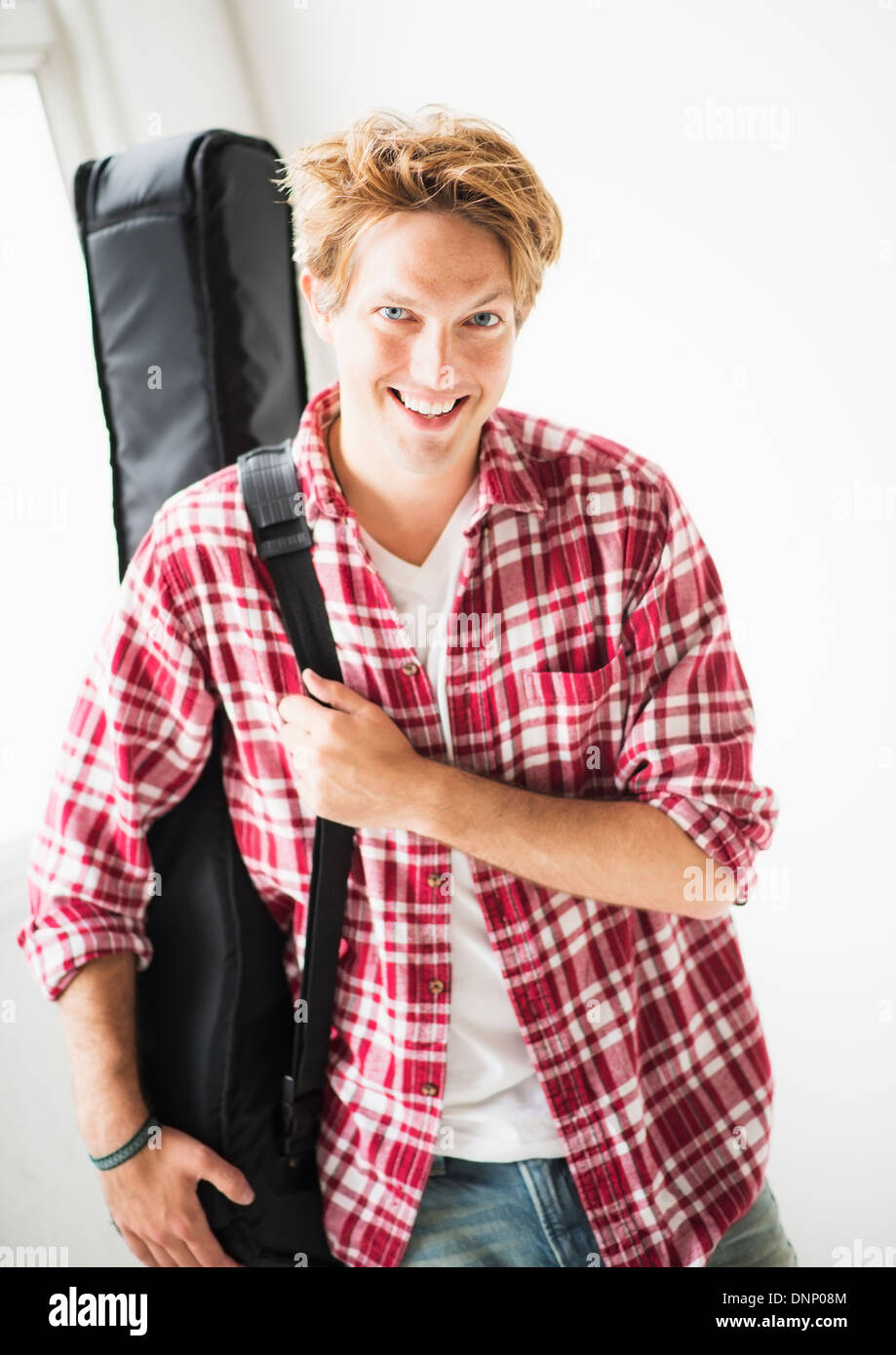 Portrait of man carrying guitar bag Stock Photo Alamy