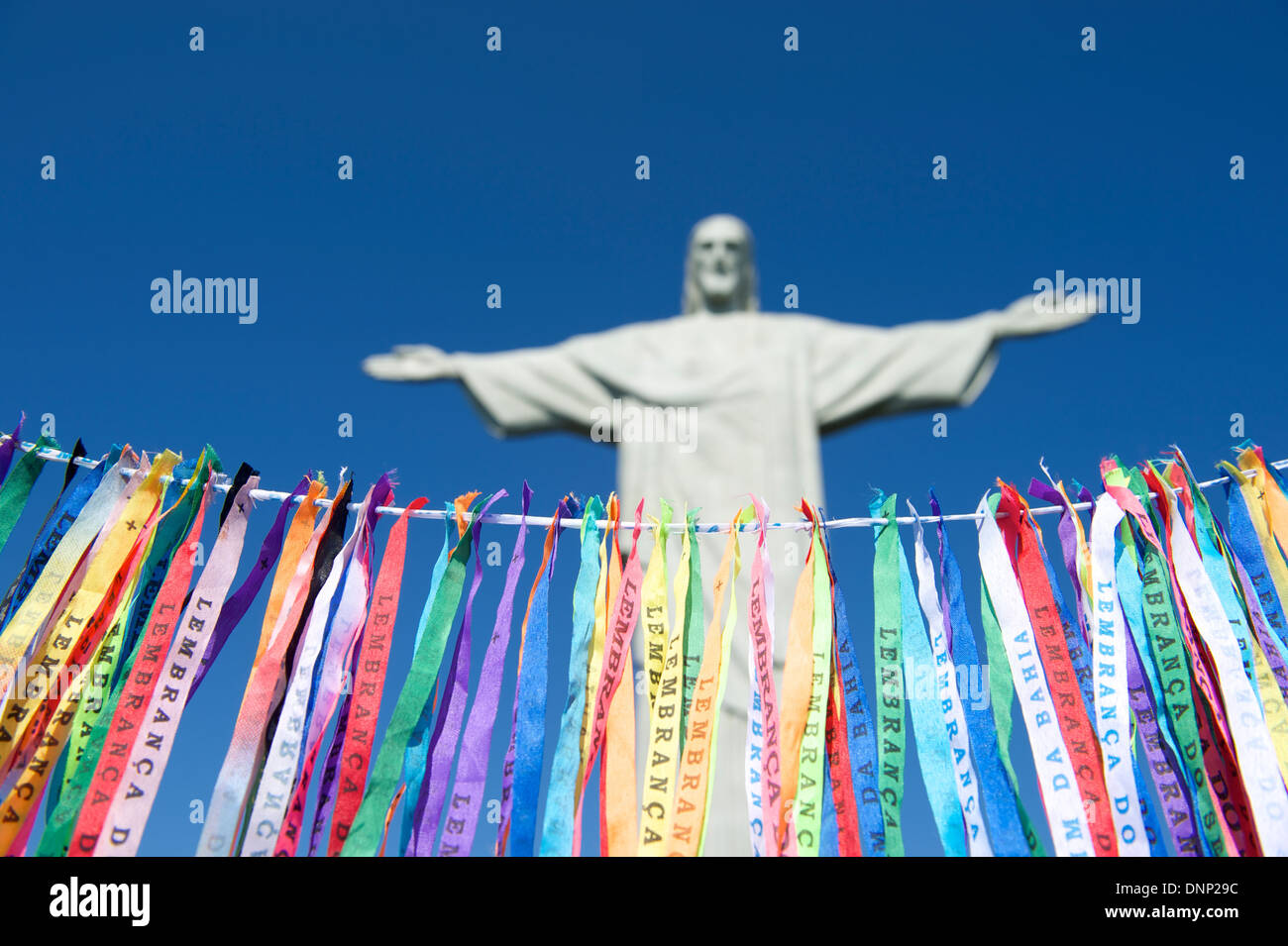 Fita do Bonfim Brazilian wish ribbons strung in blue sky at Corcovado Christ the Redeemer statue Rio de Janeiro Stock Photo