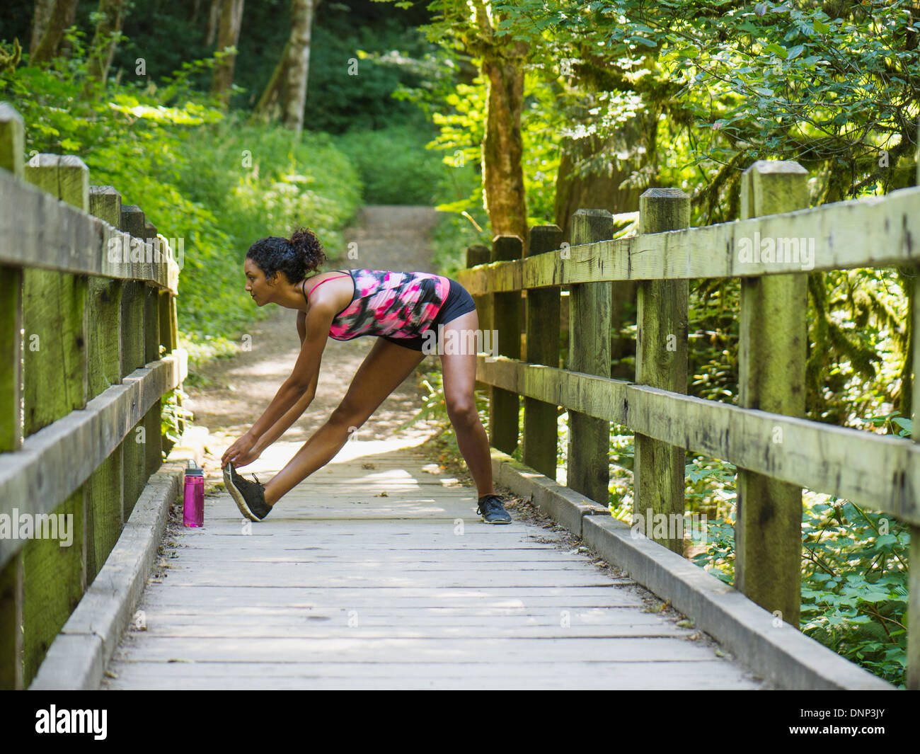 USA, Oregon, Portland, Young women stretching on footbridge Stock Photo