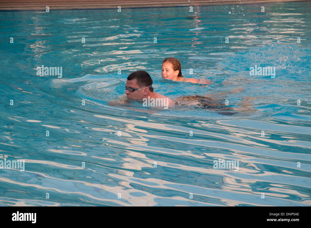 Two swimmers a father and daughter in the swimming pool of Nairobi Serena Hotel Kenya Stock Photo