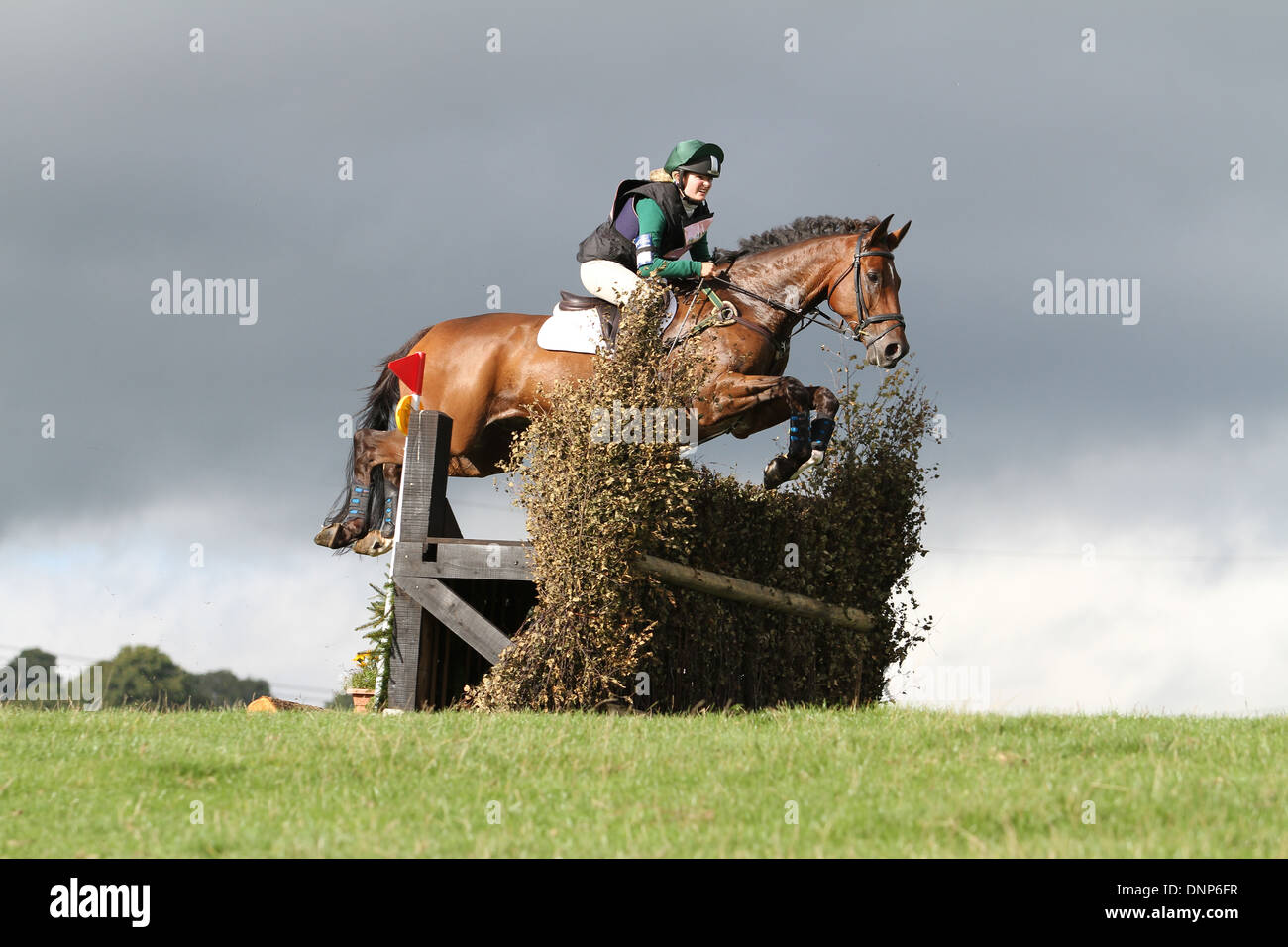 Horse and rider jumping a fence, from a low vantage point looking