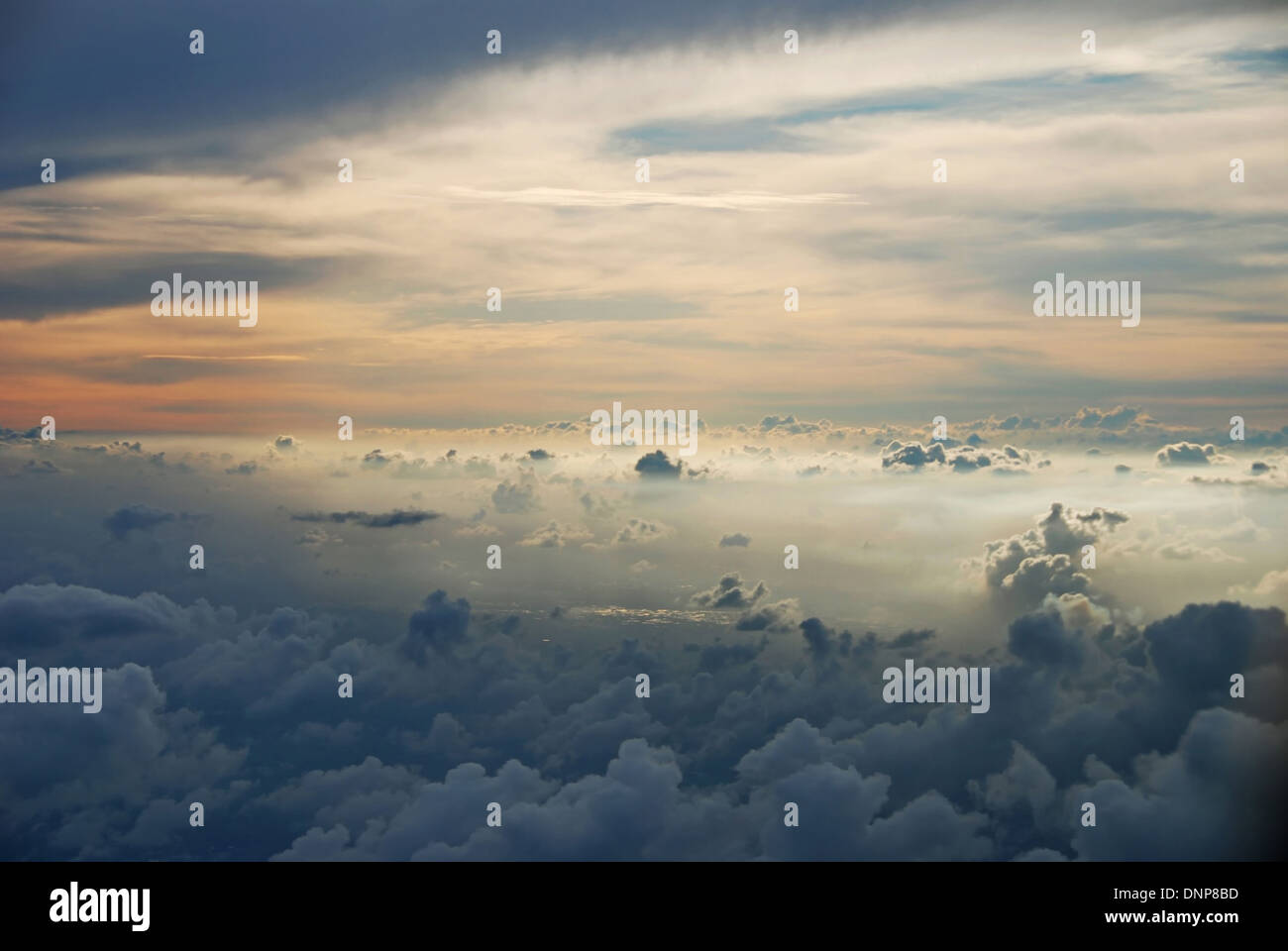 View of the sky from an airplane with clouds at sunset Stock Photo