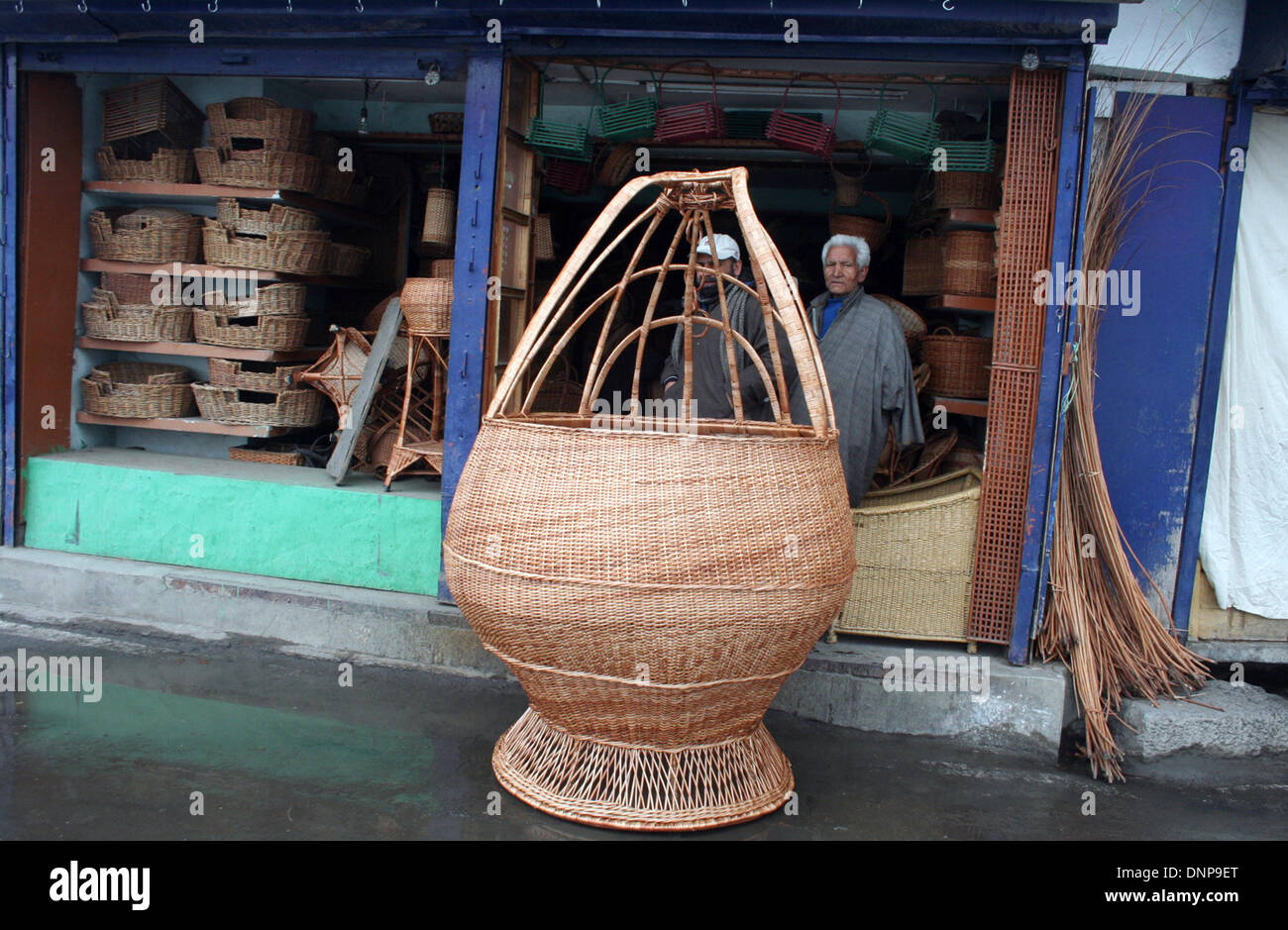 Srinagar, Indian Administered Kashmir03 January) A kashmiri 65 old man Ghulam nabi shaksaaz next right side  his shop Display A  hand made traditional 7 feet  fire pot as kashmir knowns (kangri) of worth rupees indian 25000 shahksaaz says fire pot complete 17 days   The Kangri is an earthenware container with an outer encasement of wickerwork, filled with burning coal and carried under the clothing for heat in winter months in srinagar (Sofi Suhail/ Alamy Live News Stock Photo