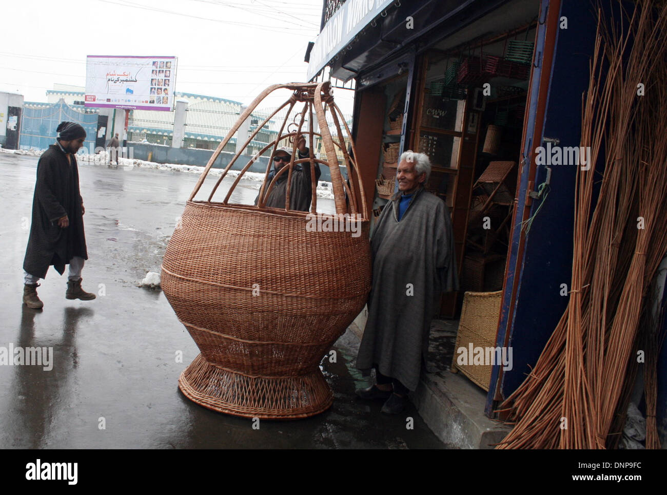 Srinagar, Indian Administered Kashmir03 January) A kashmiri 65 old man Ghulam nabi shaksaaz next right side  his shop Display A  hand made traditional 7 feet  fire pot as kashmir knowns (kangri) of worth rupees indian 25000 shahksaaz says fire pot complete 17 days   The Kangri is an earthenware container with an outer encasement of wickerwork, filled with burning coal and carried under the clothing for heat in winter months in srinagar (Sofi Suhail/ Alamy Live News Stock Photo