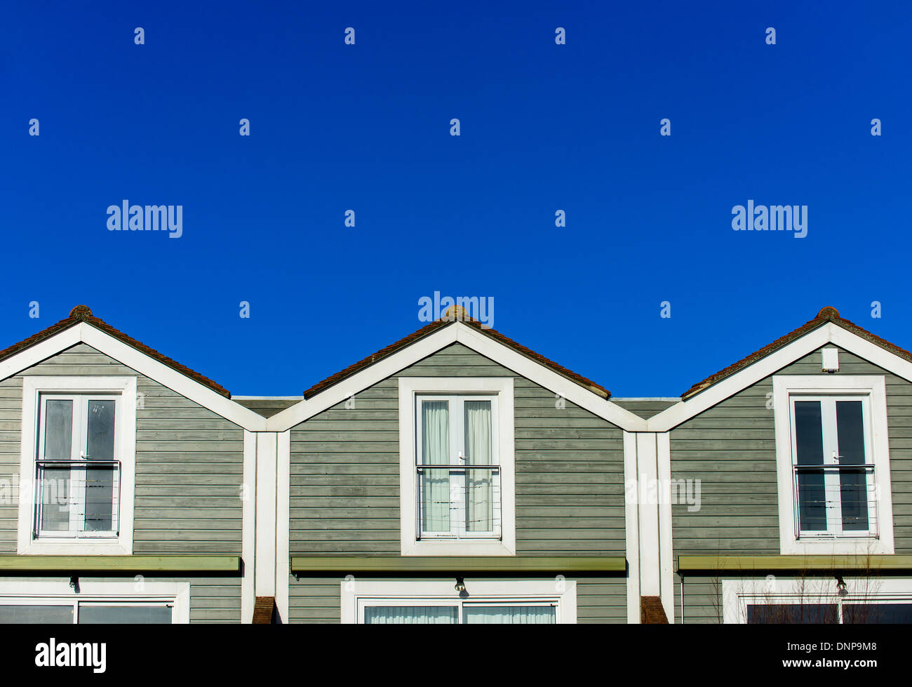 Pattern formed by the roofs of three terraced houses, with blue sky, in Bosham, West Sussex, England. Stock Photo