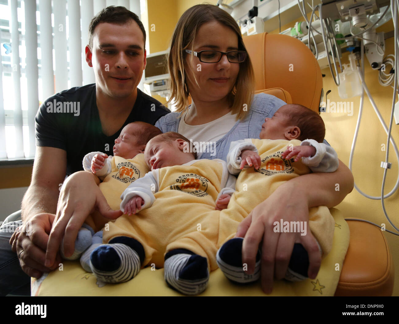 The triplets (L-R) Till, Max and Ben lie in the arms of their parents Thomas and Marie Osswald in the South City Hospital in Rostock, Germany, 03 January 2014. Four months after their birth on 06 September 2013, the triplets are now discharged home. The boys were born with a weight of 1200 to 1320 grams after only 29 weeks of gestation. Photo: Bernd Wuestneck ZB Stock Photo