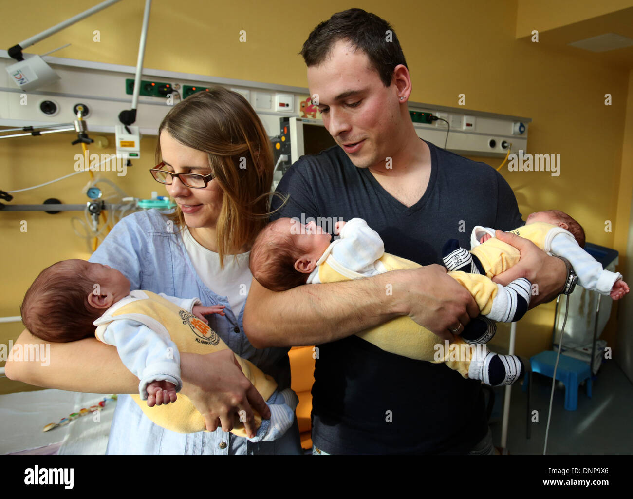 The triplets (L-R) Till, Max and Ben lie in the arms of their parents Thomas and Marie Osswald in the South City Hospital in Rostock, Germany, 03 January 2014. Four months after their birth on 06 September 2013, the triplets are now discharged home. The boys were born with a weight of 1200 to 1320 grams after only 29 weeks of gestation. Photo: Bernd Wuestneck ZB Stock Photo