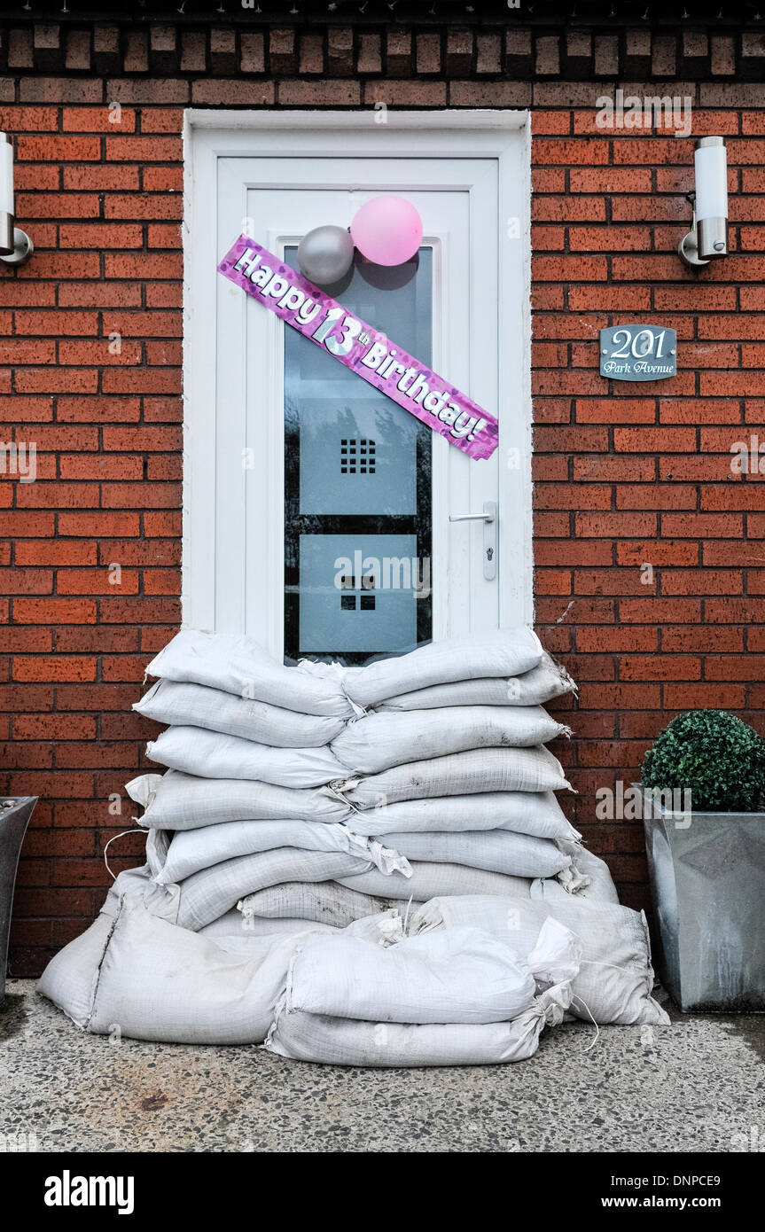 Sandbags are placed in front of a door where a girl is celebrating her 13th Birthday Stock Photo