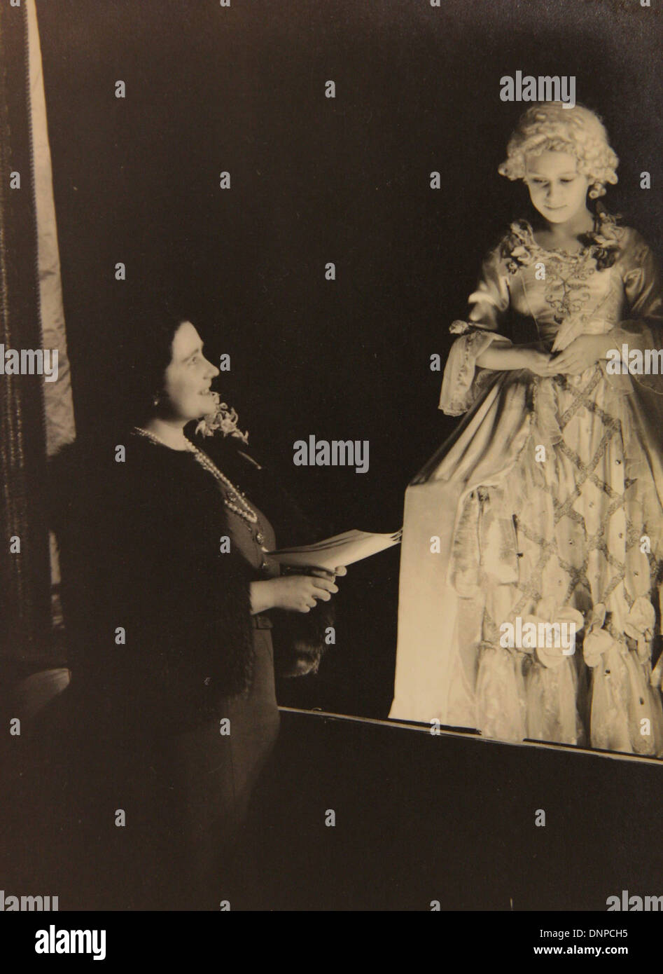 A photograph of Princess Margaret meeting the Queen Mother on the set of the play Aladdin, 1943, Stock Photo