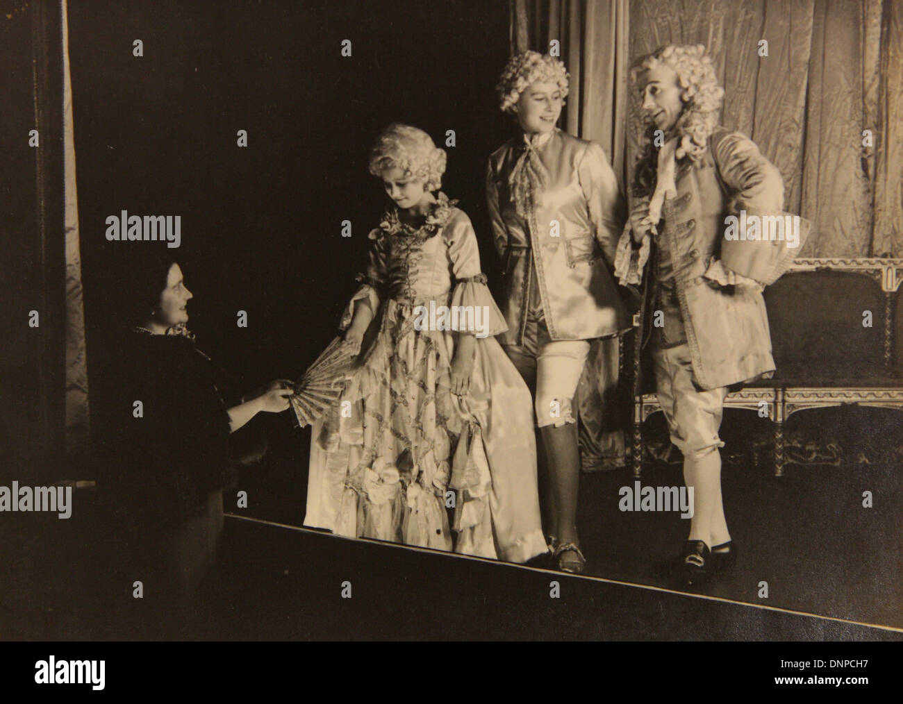 A photograph of Princess Margaret (left) and Princess Elizabeth (middle) meeting the Queen Mother on the set of the play Aladdin Stock Photo