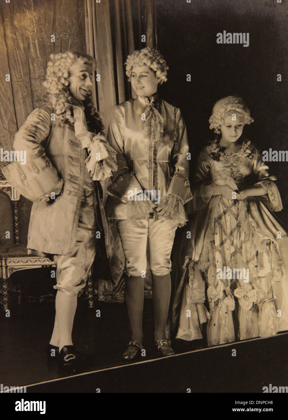 A photograph of Princess Margaret (right) and Princess Elizabeth (middle) in the play Aladdin, 1943 Stock Photo