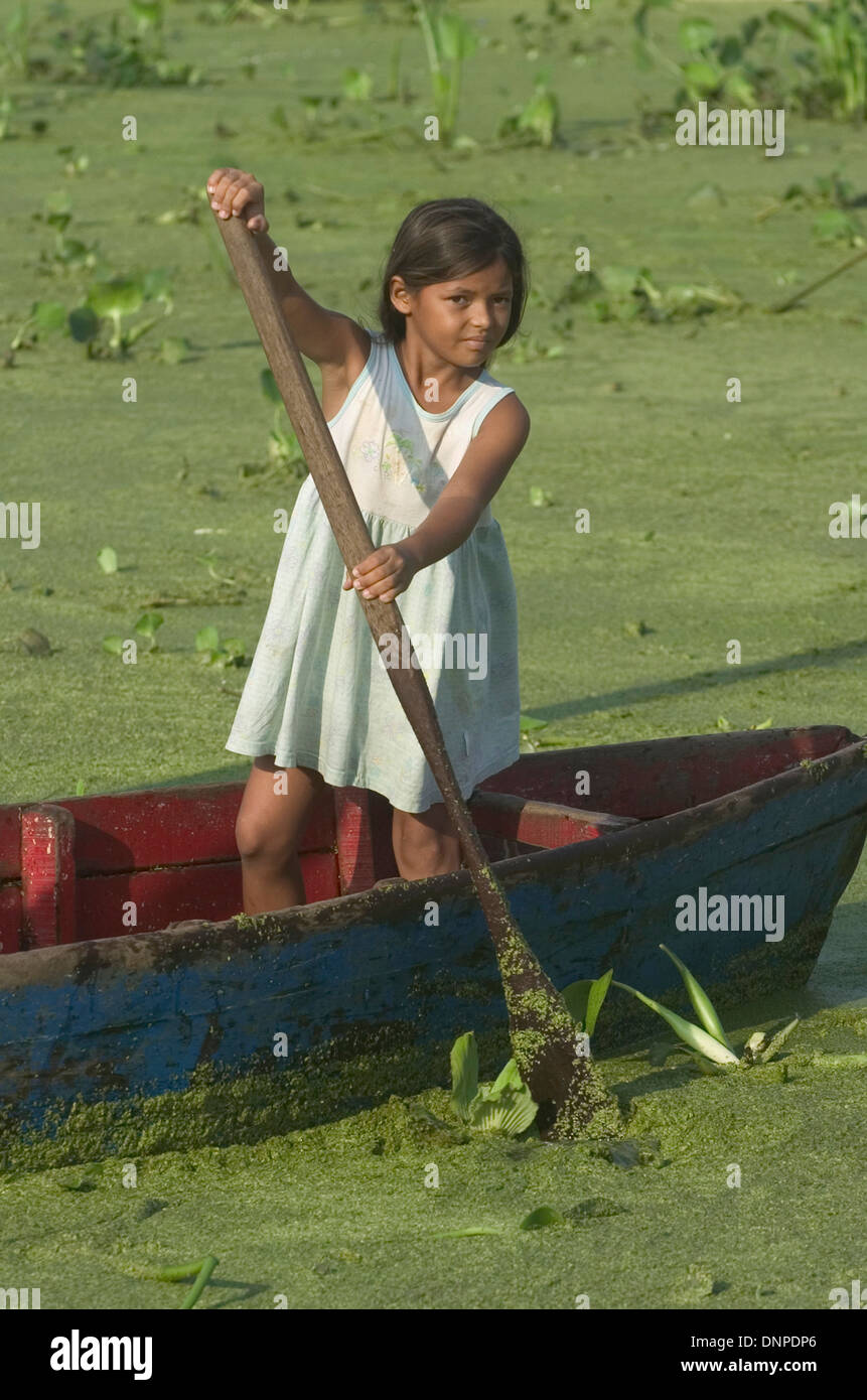 Portrait of a girl in Congo Mirador village as she rows a boat in waters covered with lemma plants, in Maracaibo lake, Venezuela Stock Photo